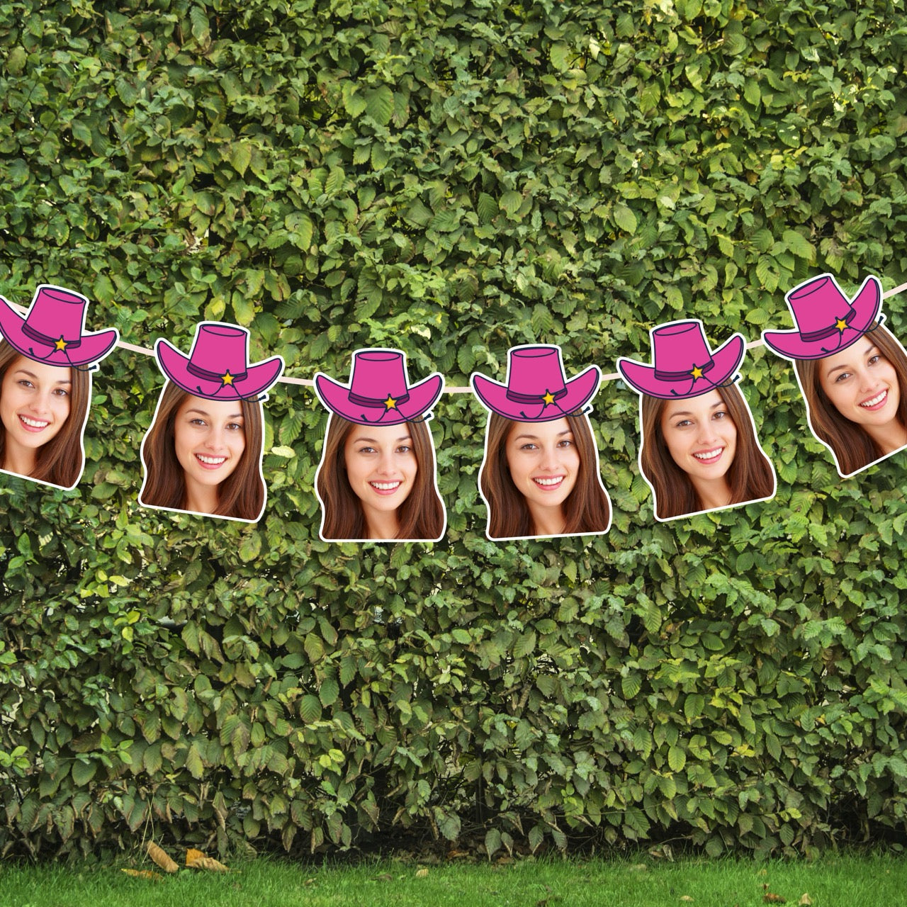 String of cutouts with faces wearing pink cowboy hats against a green hedge background