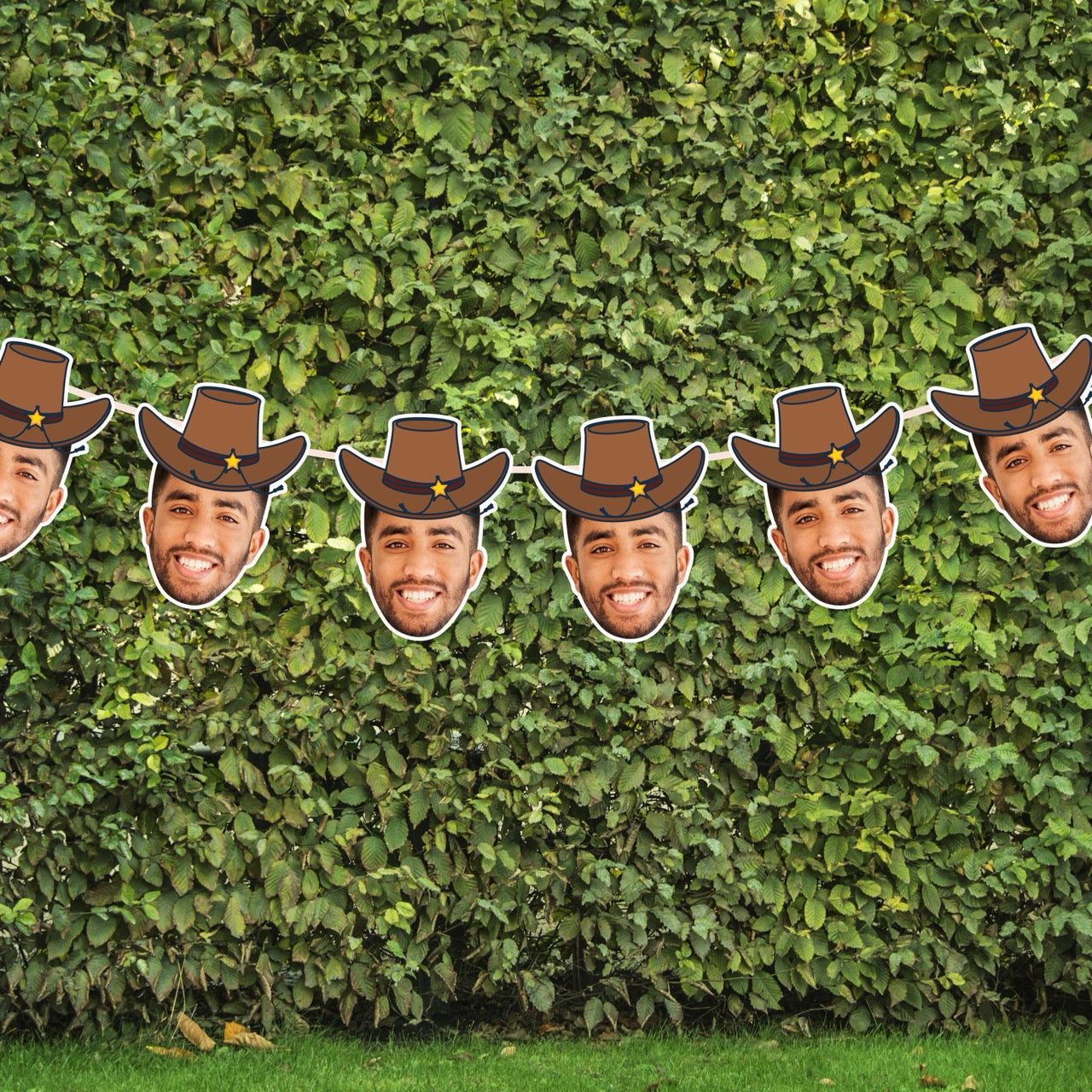 Mannequin heads with cowboy hats arranged against a green hedge.
