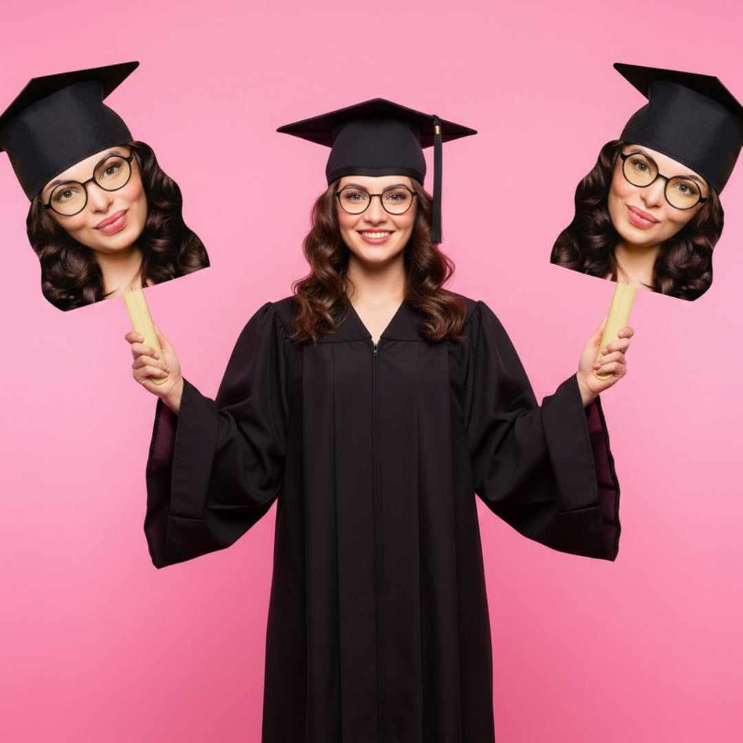 Graduate in cap and gown holding cutouts of a face on a pink background