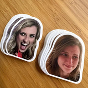 Stacks of coasters with printed faces on a wooden surface