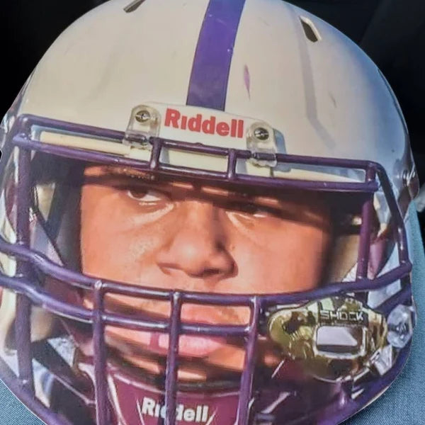 Close-up of a person wearing a football helmet with Riddell branding.