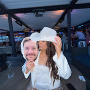 Woman holding a cardboard cutout of a man at an wedding event.