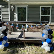 Decorative setup with balloons and cutout faces on a porch