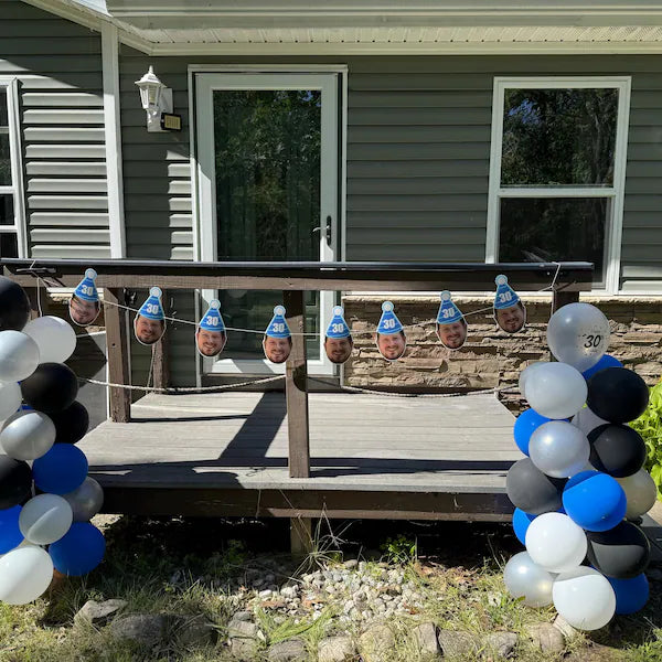 Decorative setup with balloons and cutout faces on a porch
