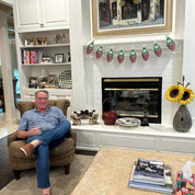 Man sitting in a chair in a living room with a fireplace and decorative items.