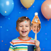Child holding a birthday hat cutout with number 4 against a blue background with balloons